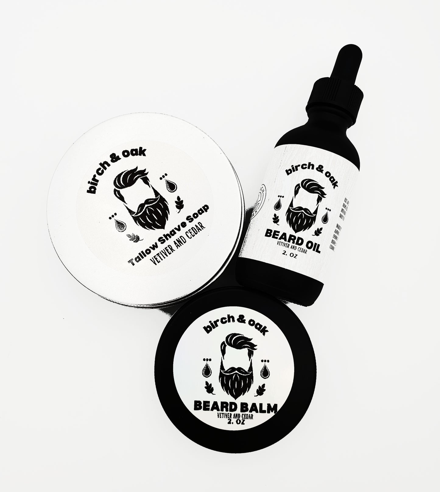A bottle of Birch & Oak Beard Oil and a container of Beard Balm, both with white labels featuring a mustache and the names of the products.
